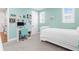 Bright bedroom featuring light-blue walls, a white bed and desk, and decoratively adorned walls at 19836 Bridgetown Loop, Venice, FL 34293