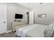 Cozy bedroom with a dresser and TV, featuring a comfortable bed and neutral decor at 19836 Bridgetown Loop, Venice, FL 34293