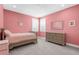 Cozy pink bedroom with neutral carpet, shuttered windows, and charming decor at 19836 Bridgetown Loop, Venice, FL 34293