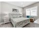 Serene bedroom featuring a stylish bed with decorative pillows, light gray walls, and wood look flooring at 19836 Bridgetown Loop, Venice, FL 34293