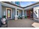 Inviting front porch with brick flooring, comfortable seating, and charming decor elements at 19836 Bridgetown Loop, Venice, FL 34293