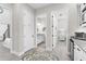 Inviting hallway with decorative rug, white trim, and access to the powder room and guest bedroom at 19836 Bridgetown Loop, Venice, FL 34293