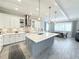 Open kitchen featuring stainless steel appliances, pendant lighting, and a large center island at 19836 Bridgetown Loop, Venice, FL 34293