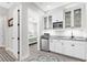 Convenient kitchenette featuring white cabinets, stainless steel appliances, and a view to the bedroom at 19836 Bridgetown Loop, Venice, FL 34293