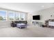 Bright living room with a comfortable gray sofa, entertainment center, and neutral walls at 19836 Bridgetown Loop, Venice, FL 34293