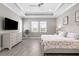 Serene main bedroom with tray ceiling, neutral tones, plantation shutters, and an en-suite bathroom at 19836 Bridgetown Loop, Venice, FL 34293