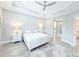 Serene main bedroom featuring a tray ceiling, soft lighting, and neutral decor at 19836 Bridgetown Loop, Venice, FL 34293