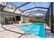 Large screened-in pool features an outdoor kitchen, dining area, and beautiful backyard views at 19836 Bridgetown Loop, Venice, FL 34293