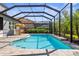 Inviting screened-in pool area featuring a clear blue swimming pool and lounge area with sunshade at 19836 Bridgetown Loop, Venice, FL 34293