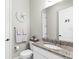Stylish powder room featuring granite countertops, a modern faucet, and decorative wall accents at 19836 Bridgetown Loop, Venice, FL 34293