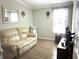 Comfortable living room with a leather sofa, wood floors, and natural light from a window at 242 Blackburn Blvd, North Port, FL 34287