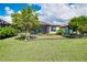 View of backyard and screened-in patio with well-maintained lawn and landscaping at 24229 Spartina Dr, Venice, FL 34293