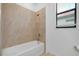 Clean bathroom features a shower and tub combination with neutral tile at 24229 Spartina Dr, Venice, FL 34293