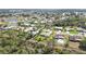An aerial view of a residential neighborhood featuring single-Gathering homes, lush greenery, and a tranquil pond at 407 Rubens Dr, Nokomis, FL 34275