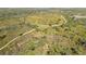 An aerial view showcases lush landscaping, walking paths, and native trees at 407 Rubens Dr, Nokomis, FL 34275
