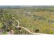 An aerial view showcases lush landscaping, walking paths, and native trees at 407 Rubens Dr, Nokomis, FL 34275