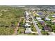 Aerial view of a neighborhood with mature trees, sidewalks, and a pond at 407 Rubens Dr, Nokomis, FL 34275