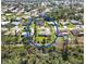 Aerial view of the property in a residential neighborhood, surrounded by lush green landscape and mature trees at 407 Rubens Dr, Nokomis, FL 34275