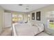 Cozy bedroom with soft carpet, large windows and natural light with access to the sunroom at 407 Rubens Dr, Nokomis, FL 34275