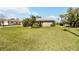 Inviting single-story home with lush green lawn and vibrant tropical landscaping at 407 Rubens Dr, Nokomis, FL 34275
