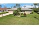 Well-maintained single-story home with a large manicured lawn and lovely landscaping at 407 Rubens Dr, Nokomis, FL 34275