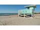 The lifeguard stand sits on the sandy beach with ocean water in the background at 407 Rubens Dr, Nokomis, FL 34275