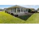 Sunroom with stone patio, providing an area for relaxation and enjoying the outdoor scenery, creating a cozy outdoor living space at 407 Rubens Dr, Nokomis, FL 34275