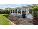Outdoor patio off the sunroom with stone flooring, seating, and a grill, perfect for outdoor dining and entertaining at 407 Rubens Dr, Nokomis, FL 34275
