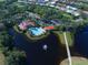 Stunning aerial view of community pool, clubhouse, and surrounding homes near a scenic lake with fountain feature at 408 Otter Creek Dr, Venice, FL 34292
