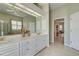 Bathroom featuring a large mirror, double sinks, granite countertop, storage cabinets, and interior access at 408 Otter Creek Dr, Venice, FL 34292