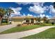 Inviting one-story home with well-maintained lawn, mature palms, and paved walkway at 408 Otter Creek Dr, Venice, FL 34292