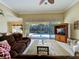 Comfortable living room with tile floors, a ceiling fan, and a view of the screened pool area at 408 Otter Creek Dr, Venice, FL 34292