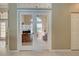 The glass french doors provide a view into the carpeted office with lots of light and a ceiling fan at 408 Otter Creek Dr, Venice, FL 34292