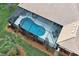 Aerial view of kidney-shaped pool enclosed in screened lanai with outdoor seating and tiled roof at 408 Otter Creek Dr, Venice, FL 34292