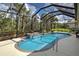 Inviting screened-in pool with a waterfall feature surrounded by tropical plants and landscaping at 408 Otter Creek Dr, Venice, FL 34292