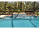 Close up of pool waterfall feature with decorative tile work and lush surrounding foliage at 408 Otter Creek Dr, Venice, FL 34292