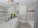 Bathroom with white cabinets, dual sinks, soaking tub, and tile shower at 501 Tamiami N Trl # 502, Venice, FL 34285
