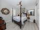 Bedroom with a four-poster bed, wood flooring, crown molding, large mirror and ceiling fan at 501 Tamiami N Trl # 502, Venice, FL 34285