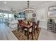 Dining room featuring a wooden table, decorative chandelier, and nearby bar area at 501 Tamiami N Trl # 502, Venice, FL 34285