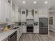 Bright kitchen featuring white cabinets, quartz countertops, stainless steel appliances, and luxury vinyl flooring at 501 Tamiami N Trl # 502, Venice, FL 34285