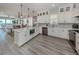 Bright kitchen featuring white cabinets, quartz countertops, stainless steel appliances and luxury vinyl flooring at 501 Tamiami N Trl # 502, Venice, FL 34285