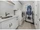 A well-organized laundry room with modern appliances, sink, and storage cabinets at 501 Tamiami N Trl # 502, Venice, FL 34285