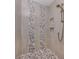 Modern shower with neutral tiles, accent stones, and convenient shelving niches at 501 Tamiami N Trl # 502, Venice, FL 34285