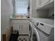 Laundry room with white cabinets, sink, and modern, front loading washing machine and dryer at 530 Walnut Cir, Venice, FL 34285