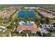 Aerial view of community pool, with umbrellas, lounge area, community center, and beautiful lake at 5665 Piccolo St, Nokomis, FL 34275