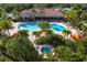 Aerial view of a community pool, hot tub, and lounge area surrounded by lush landscaping at 5665 Piccolo St, Nokomis, FL 34275