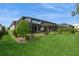 Manicured backyard with healthy lawn, mature landscaping, and a screened-in pool at 5665 Piccolo St, Nokomis, FL 34275