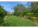 Sprawling backyard featuring lush lawn and beautiful landscaping with privacy at 5665 Piccolo St, Nokomis, FL 34275