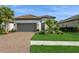 Beautiful single-story home with lush landscaping, healthy green lawn and a paver driveway at 5665 Piccolo St, Nokomis, FL 34275