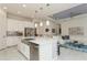 Open-concept kitchen featuring an island, stainless appliances, and breakfast bar leading into the living room at 5665 Piccolo St, Nokomis, FL 34275